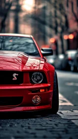 Red muscle car glows against a moody urban street backdrop