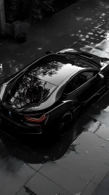 BMW i8 hybrid coupe on wet reflective driveway, rear three-quarter