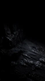 Dark rocky surface with wet reflective texture in shadow.