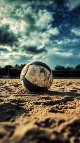 Weathered beach volleyball rests on sunlit sand court