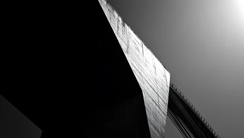 Brutalist bridge pylon in stark monochrome sunlight.