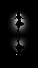 Silhouette of rotating dancer with reflective surface below.