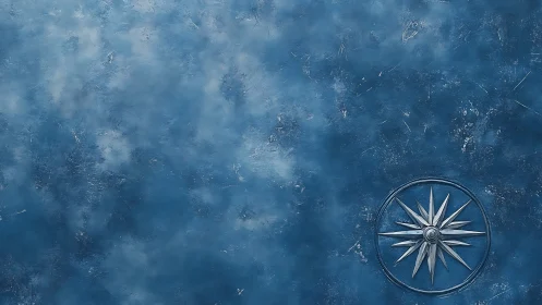 Blue textured surface with metallic compass emblem at edge.