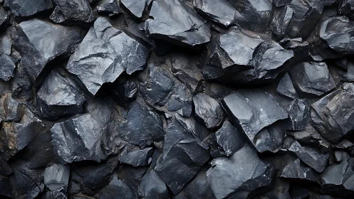 Dark fractured rock wall with sharp angular slate textures.