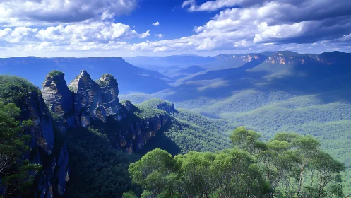 Sunlit blue mountains stretch beyond dramatic rock cliffs