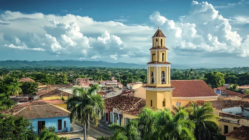 Yellow bell tower rises over tiled roofs and green landscape