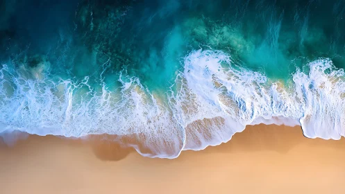 Aerial shoreline view with waves on smooth sandy beach.
