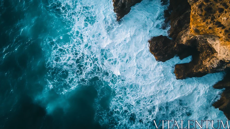 Turquoise waves greeting golden sea cliffs from above.