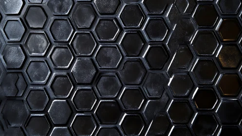 Dark metallic hexagon grid forms sleek industrial surface.