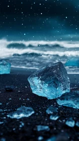Blue ice fragments on dark beach under falling snow.