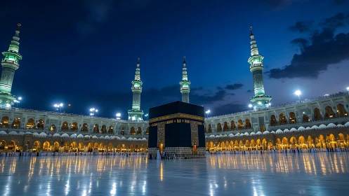 Central Kaaba structure in illuminated mosque courtyard at dusk.