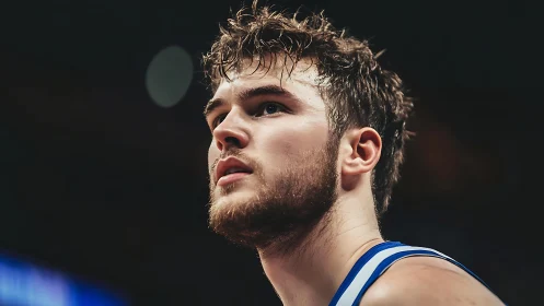 Focused basketball player gazes upward under arena lights