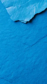 Torn blue paper texture with high contrast surface details.