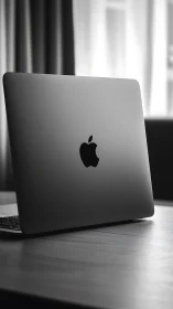 Sleek laptop rests calmly on a sunlit wooden desk