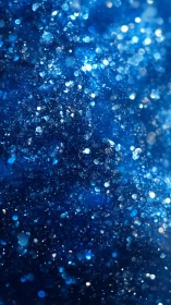 Deep blue glitter macro texture with bright bokeh sparkles.