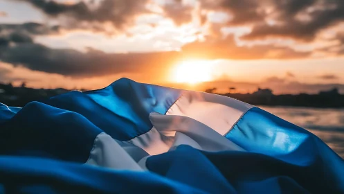 Blue and white striped fabric against coastal sunset horizon.