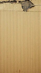 Corrugated cardboard curtain peeling to reveal hidden layers.