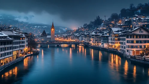 Snowy riverside town at dusk with lit clock tower skyline.
