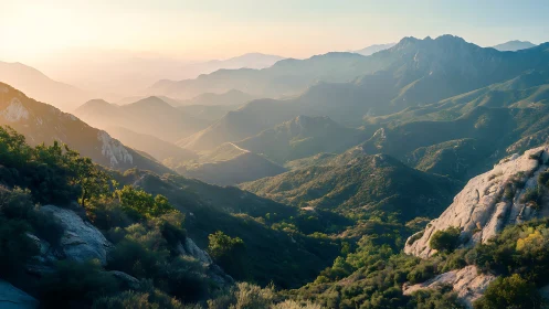 Morning haze over layered mountain ridges at sunrise.