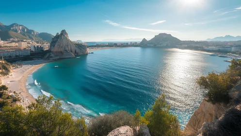 Sunlit Mediterranean bay curving beneath rocky headlands.