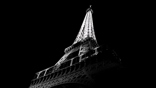 Illuminated lattice tower photographed from low angle at night