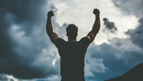 Silhouetted victor punches triumph into a stormy sky