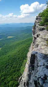 Sunlit mountain cliff overlooks endless green valley below