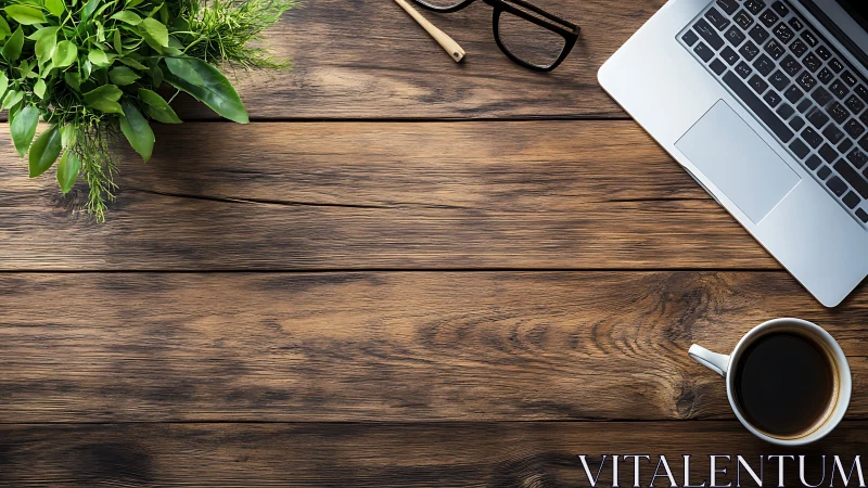 Laptop, coffee and plant on rustic wooden office desk.