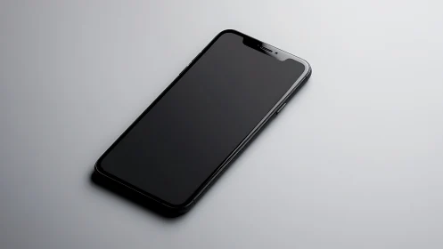 Black smartphone positioned at angle on neutral light gray surface
