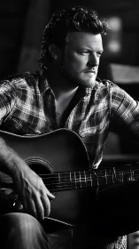 Moody country guitarist in plaid shirt under studio light.