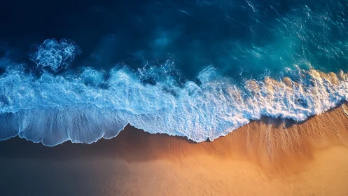 Aerial ocean surf meeting smooth golden sandy shore.