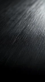 Subtle light glides over textured black abstract surface