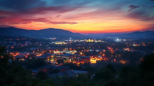 City lights under layered sunset sky over distant hills.
