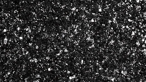 Black glitter surface shows dense reflective sparkle field.