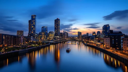 City lights drift downstream as blue-hour clouds whisper above