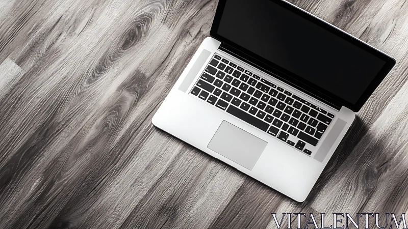 Quiet laptop on sunlit wooden floor, inviting fresh starts.