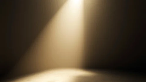 Single warm spotlight pours onto an empty stage floor.