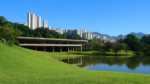 Modern pavilion, urban high-rises and lake in city park.