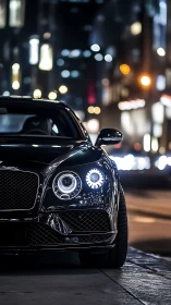 Luxury coupe with LED headlights idles on nocturnal city street