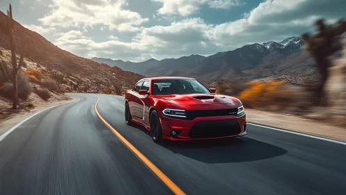 Crimson muscle car streaks through sunlit desert canyon road.