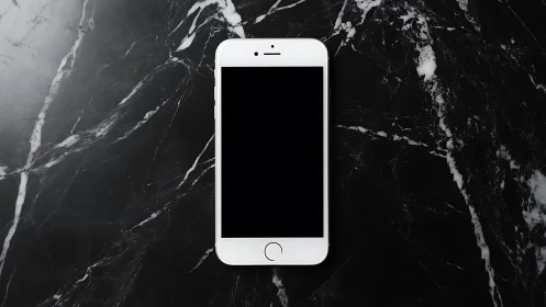 White smartphone on dark marble surface, centered composition.
