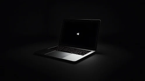 Laptop computer with Windows logo on dark background.