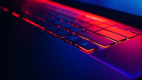 Close laptop keyboard in red and blue neon light glow.