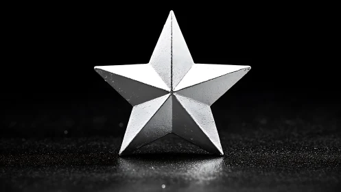 Silver metal star sculpture under dramatic studio lighting.