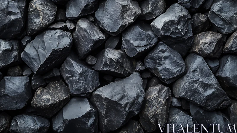 Dark coal stones lie stacked in a rugged abstract pattern