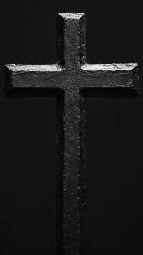 Black textured cross stands vertically against dark background