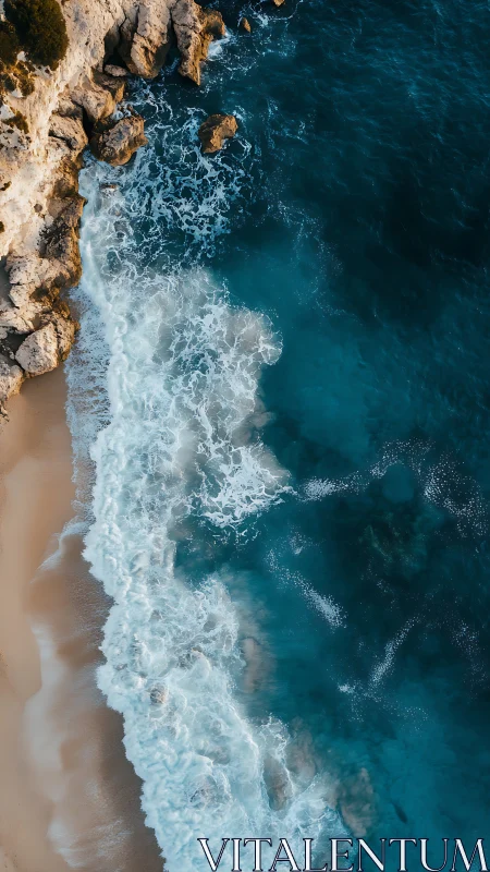 Vertical aerial coastline with waves impacting sandy beach edge