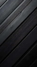 Diagonal black wooden planks form a textured linear surface