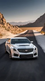 White sports sedan charging through sunlit desert highway.