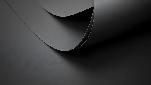 Curved matte black sheets form minimal abstract composition